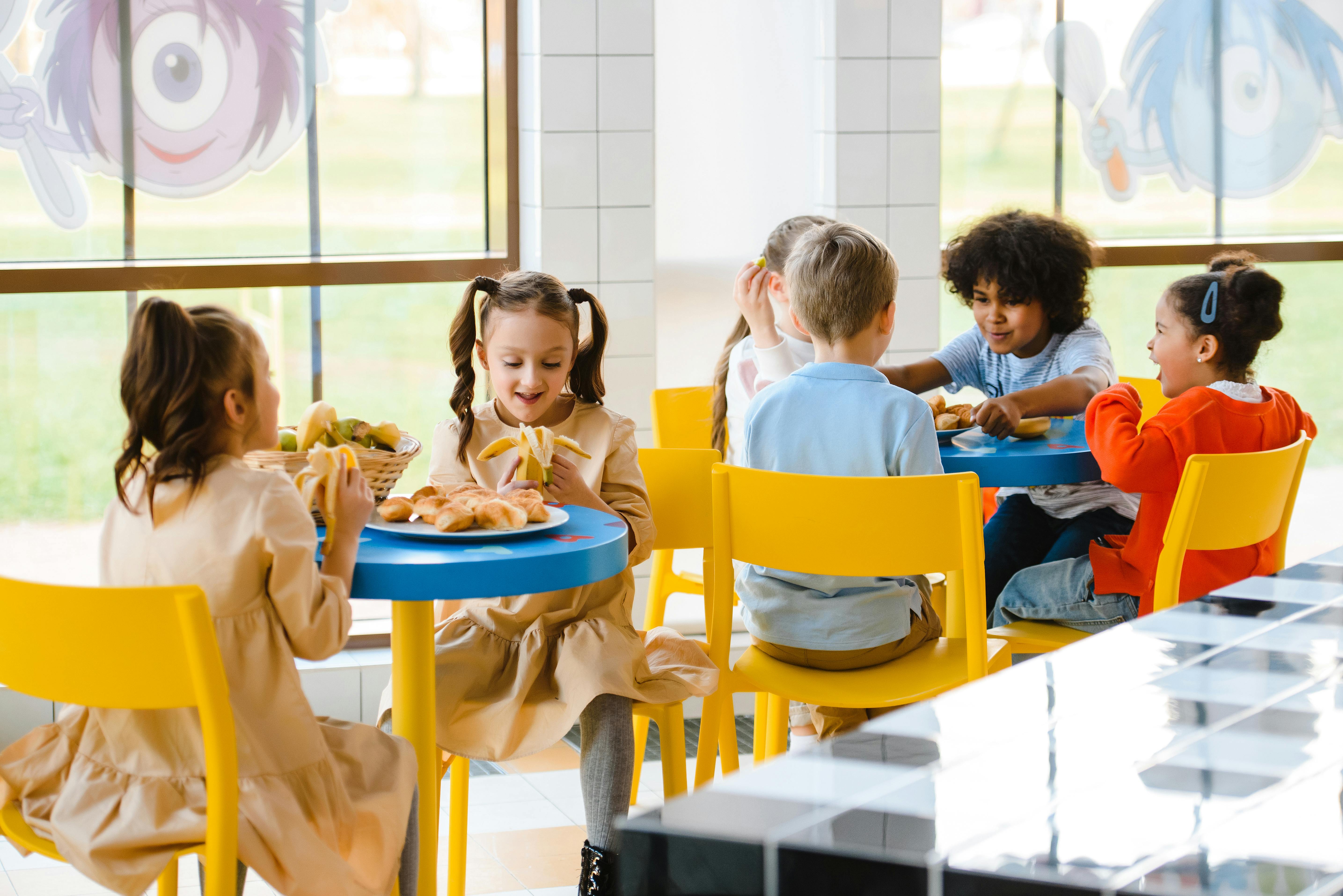 Enfant qui prennent un goûter dans une cantine